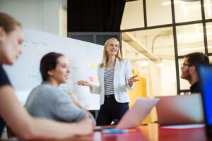 Young businesswoman giving presentation on future plans to her colleagues at office